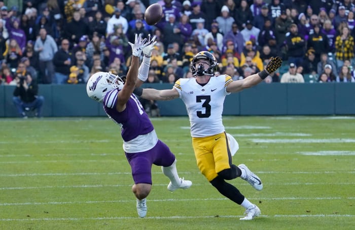 Northwestern wide receiver Cam Johnson attempts to catch a pass while defended by Iowa defensive back Cooper DeJean during the Wildcats' game against the Hawkeyes on Nov. 4, 2023.
